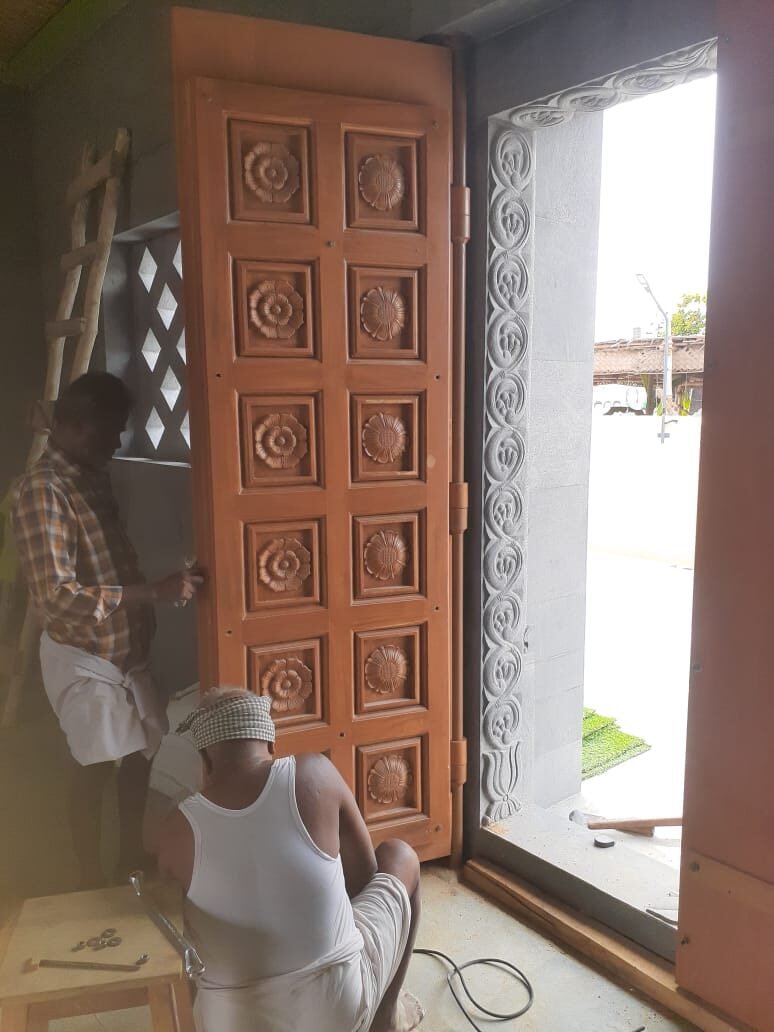 Finished carved wooden door installed at a site